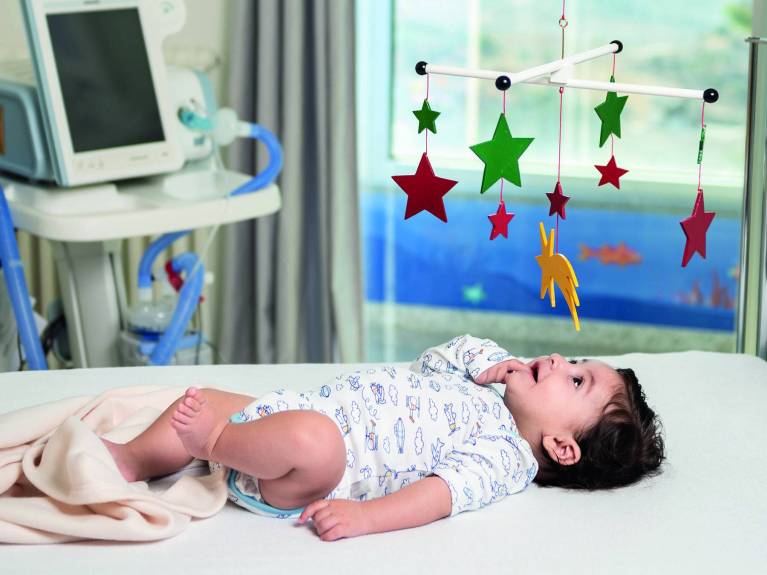 Ein Baby liegt unter Mobile